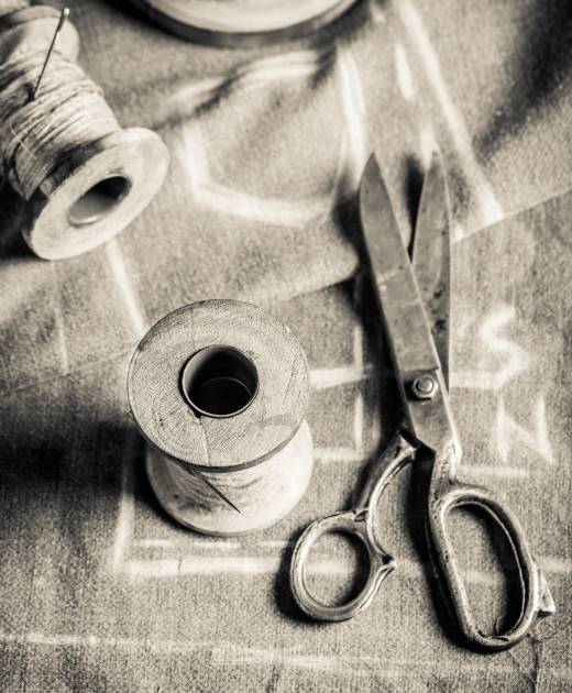 Old sewing table with scissors, threads and cloth